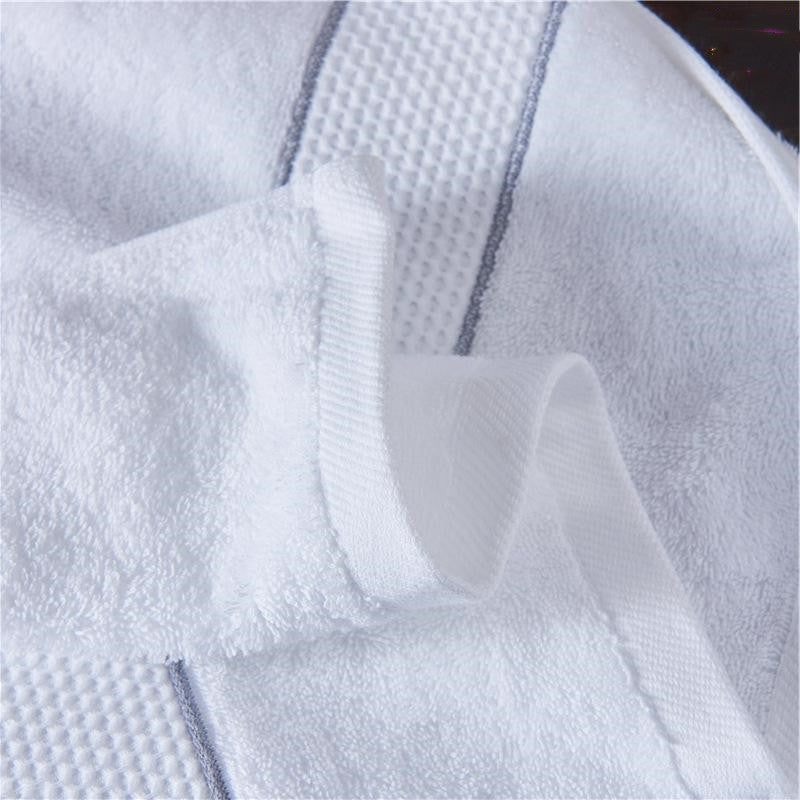 Close-up of Atelier white cotton bath towel showing jacquard weave border and plush cotton texture

