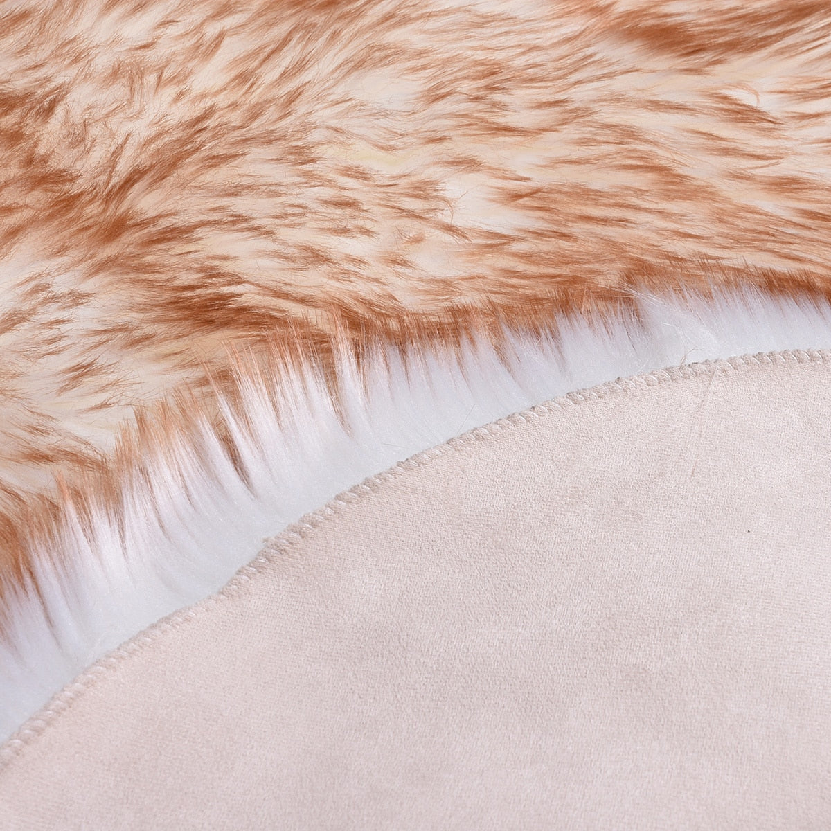 Close-up of Birino faux sheepskin heart shaped rug backing, showing suede base and stitched edge construction