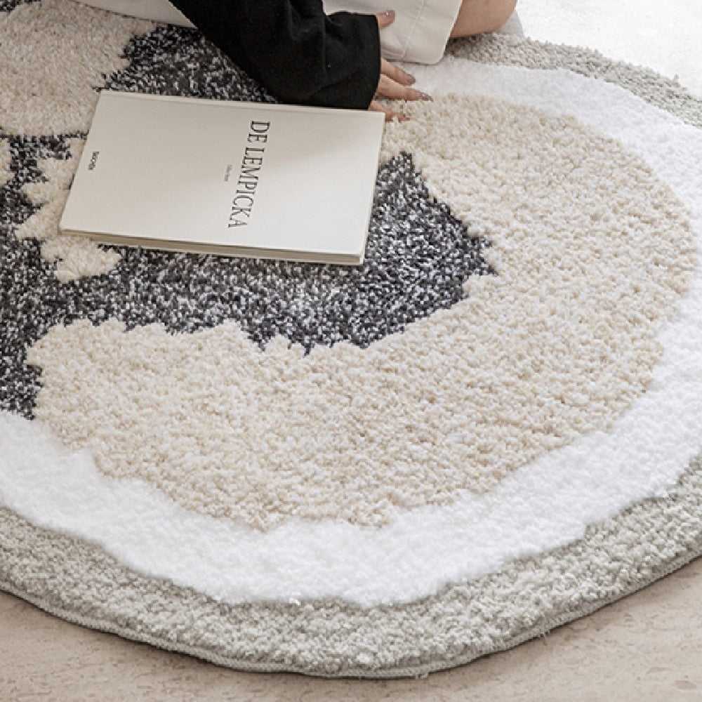 Round Schnauzer animal print rug in cream and charcoal styled with an art book in a bright minimal setting