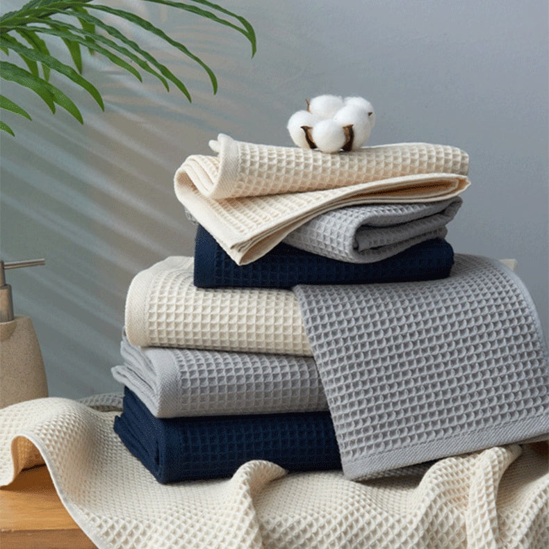 Subako waffle weave bath towels stacked in beige, grey and navy blue – premium soft absorbent luxury cotton